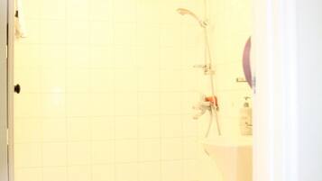 Une salle de bain avec une douche, des toilettes et un lavabo.