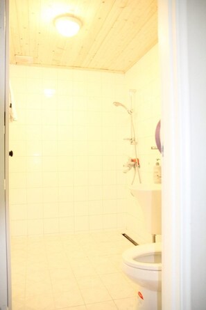Un baño con ducha, inodoro y lavamanos.