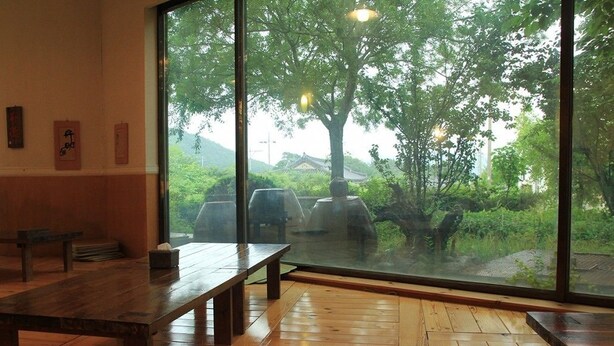 Ein Zimmer mit großem Fenster, Holzboden und einer Sitzbank.