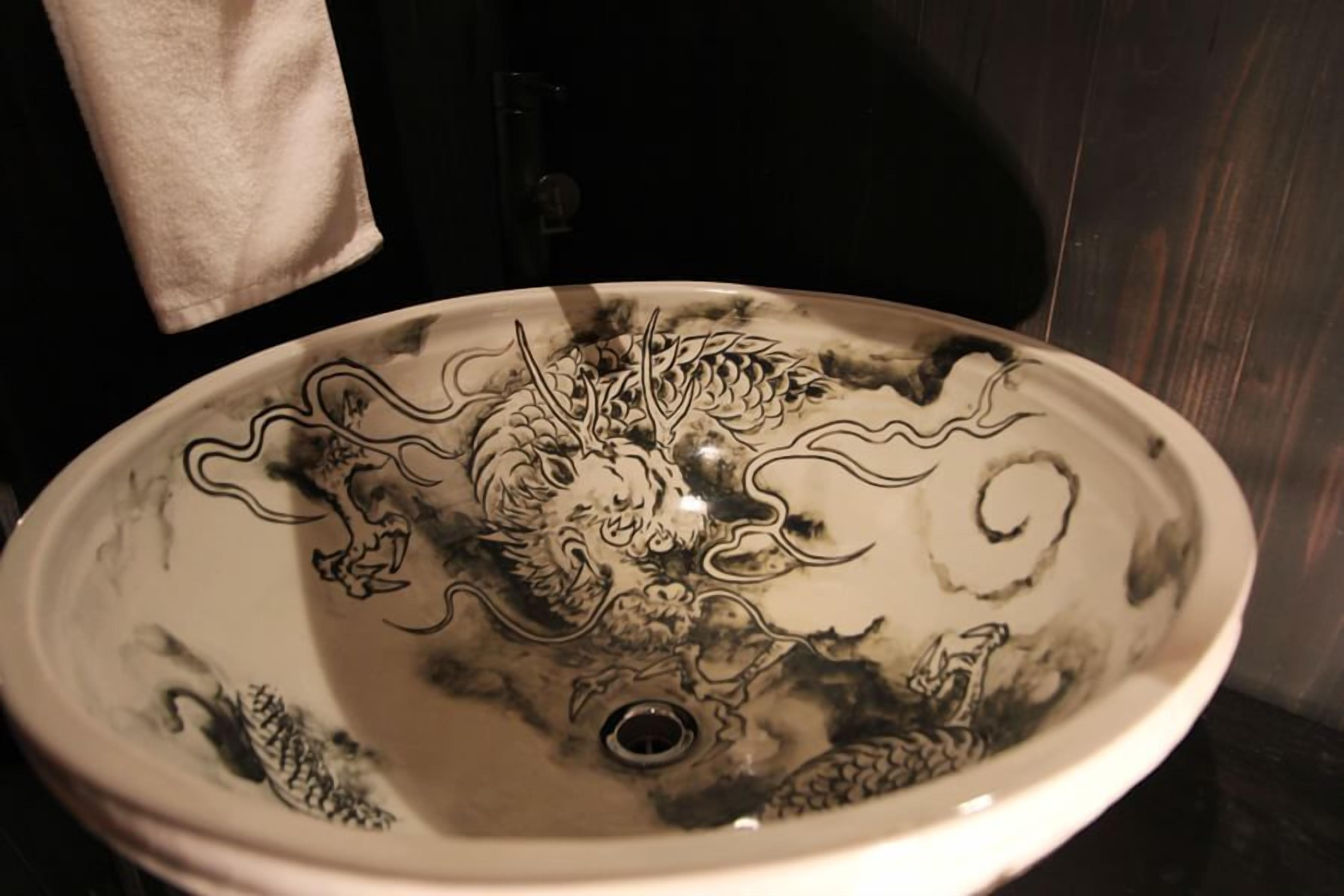 A bathroom sink with a dragon design.