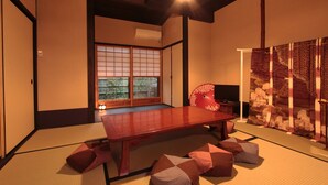 Una habitación japonesa tradicional con suelo de tatami, una mesa de madera baja y paneles shoji.