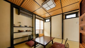 A traditional Japanese room with tatami flooring, a low table, cushions, and sliding doors. - Kikyo-an (Kyoto)