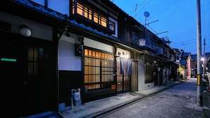 A traditional Japanese building with a wooden gate, a satellite dish, and a bicycle parked outside. - Kikyo-an (Kyoto)
