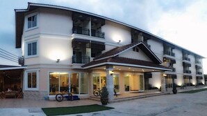A multi-story hotel with a covered outdoor seating area, large windows, and a staircase leading to the upper floors. - Chansuda Lake View Hotel (Ubon Ratchathani)