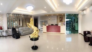A hotel lobby with a reception desk, seating area, and a decorative golden statue. - Chansuda Lake View Hotel (Ubon Ratchathani)