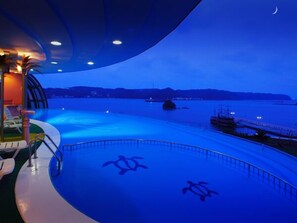 A pool area with a view of the sea and distant land.