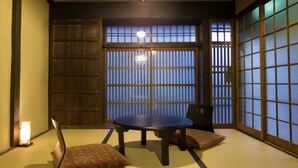 A traditional Japanese room with tatami flooring, a low table, and shoji screens. - Demizu Machiya (Kyoto)