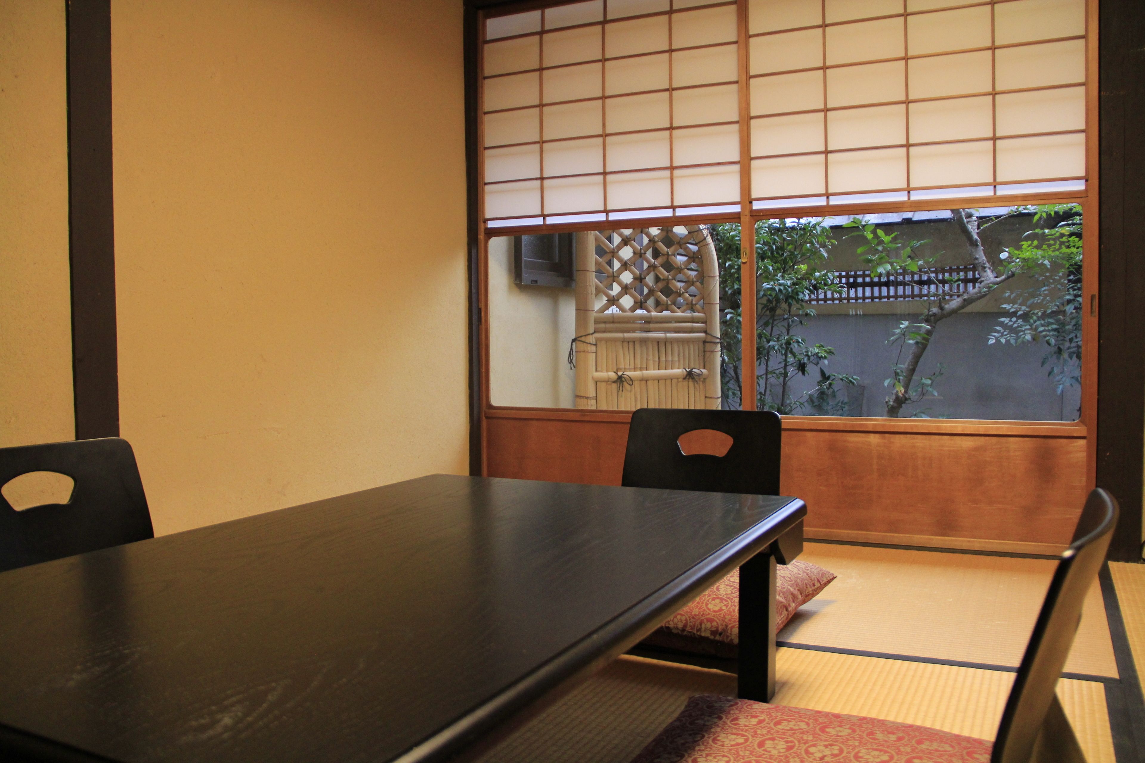 A traditional Japanese room with tatami flooring, a low table, and sliding shoji doors.