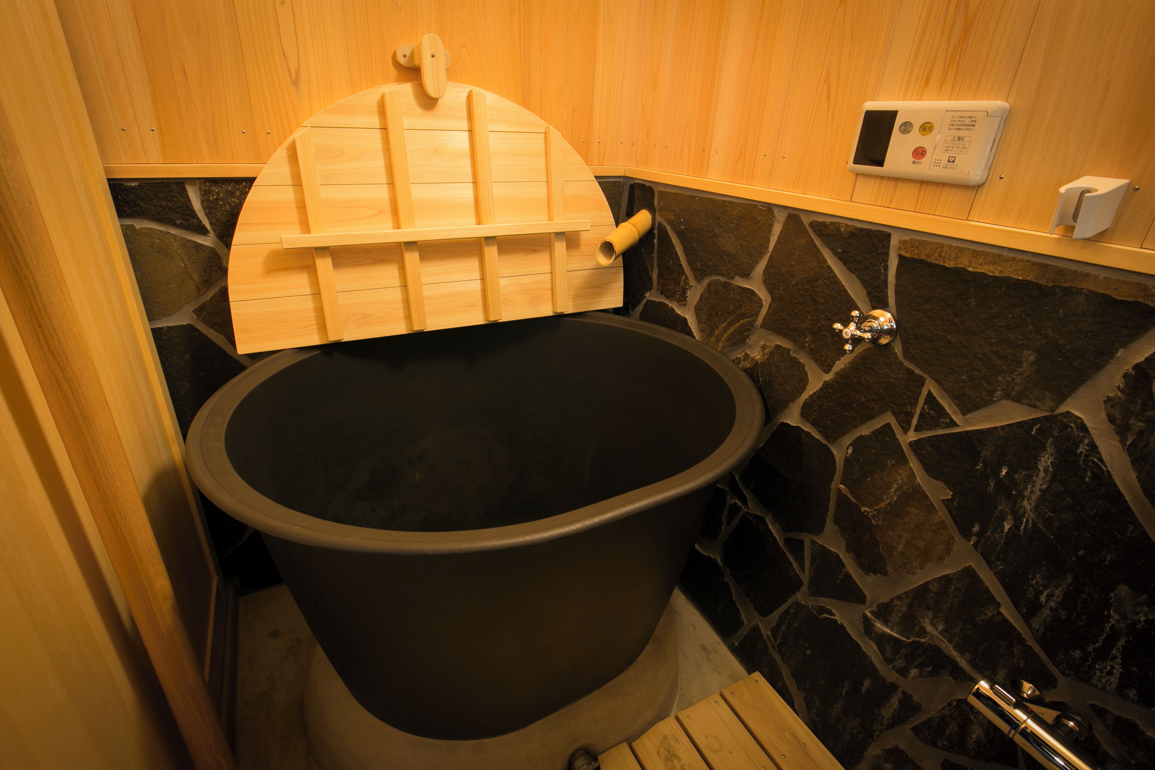 A sauna with a wooden bench and a control panel on the wall.