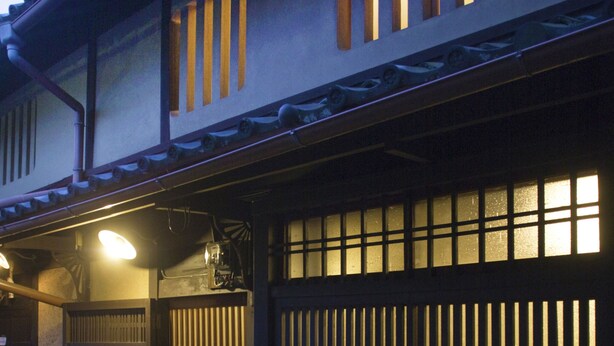A traditional Japanese building with a dark wooden gate and sliding doors. - Demizu Machiya (Kyoto)