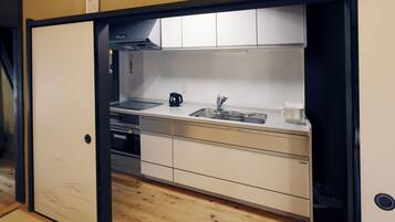 A compact kitchen with a sink, stove, and cabinets.