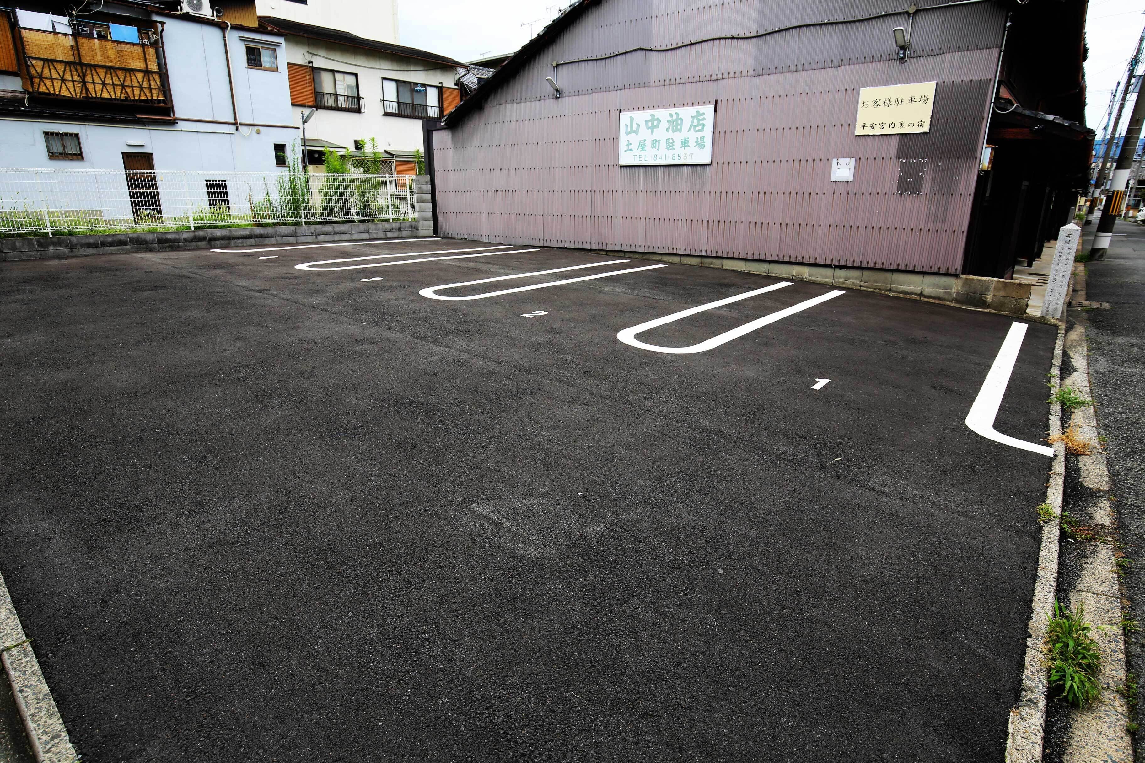 A parking lot with marked spaces and a building with a sign in Japanese.