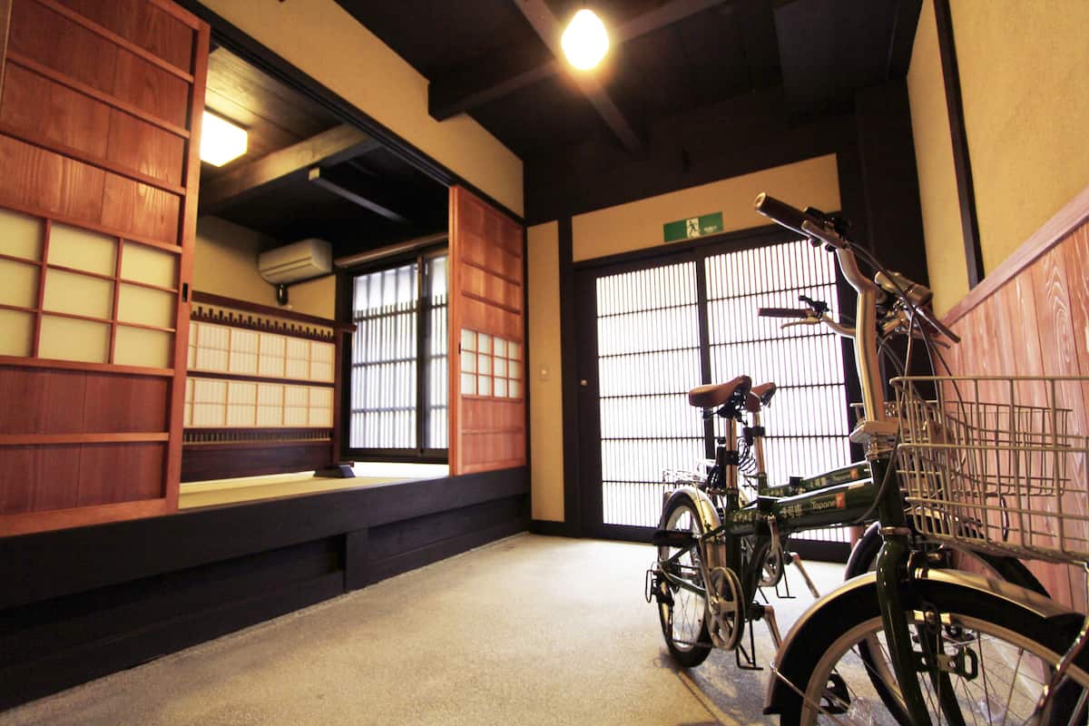 Ett traditionellt japanskt rum med tatamimattor på golvet, skjutdörrar och en cykel med en korg.