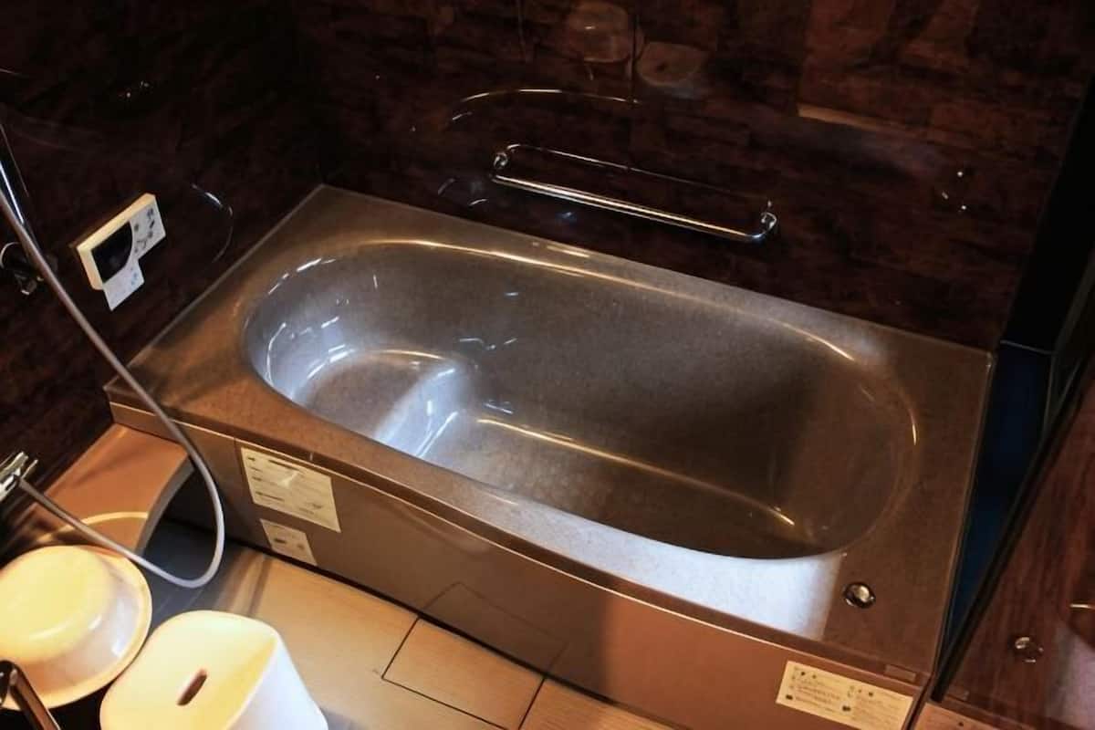 A modern bathroom with a large bathtub, a glass shower enclosure, and a visible electrical outlet.