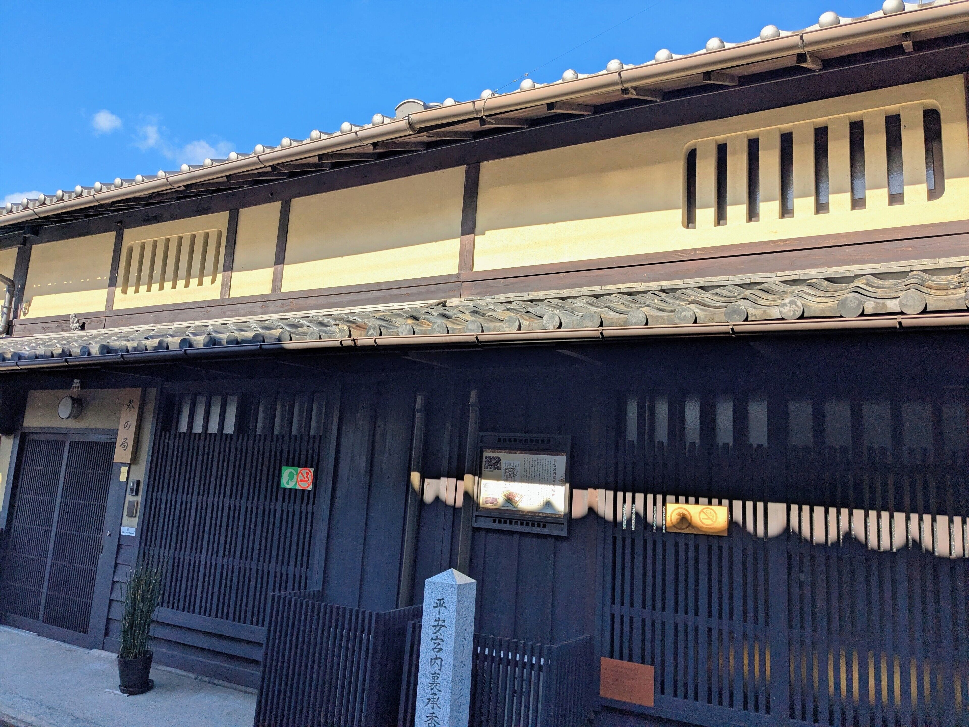 A traditional Japanese building with a tiled roof, wooden beams, and a dark facade.