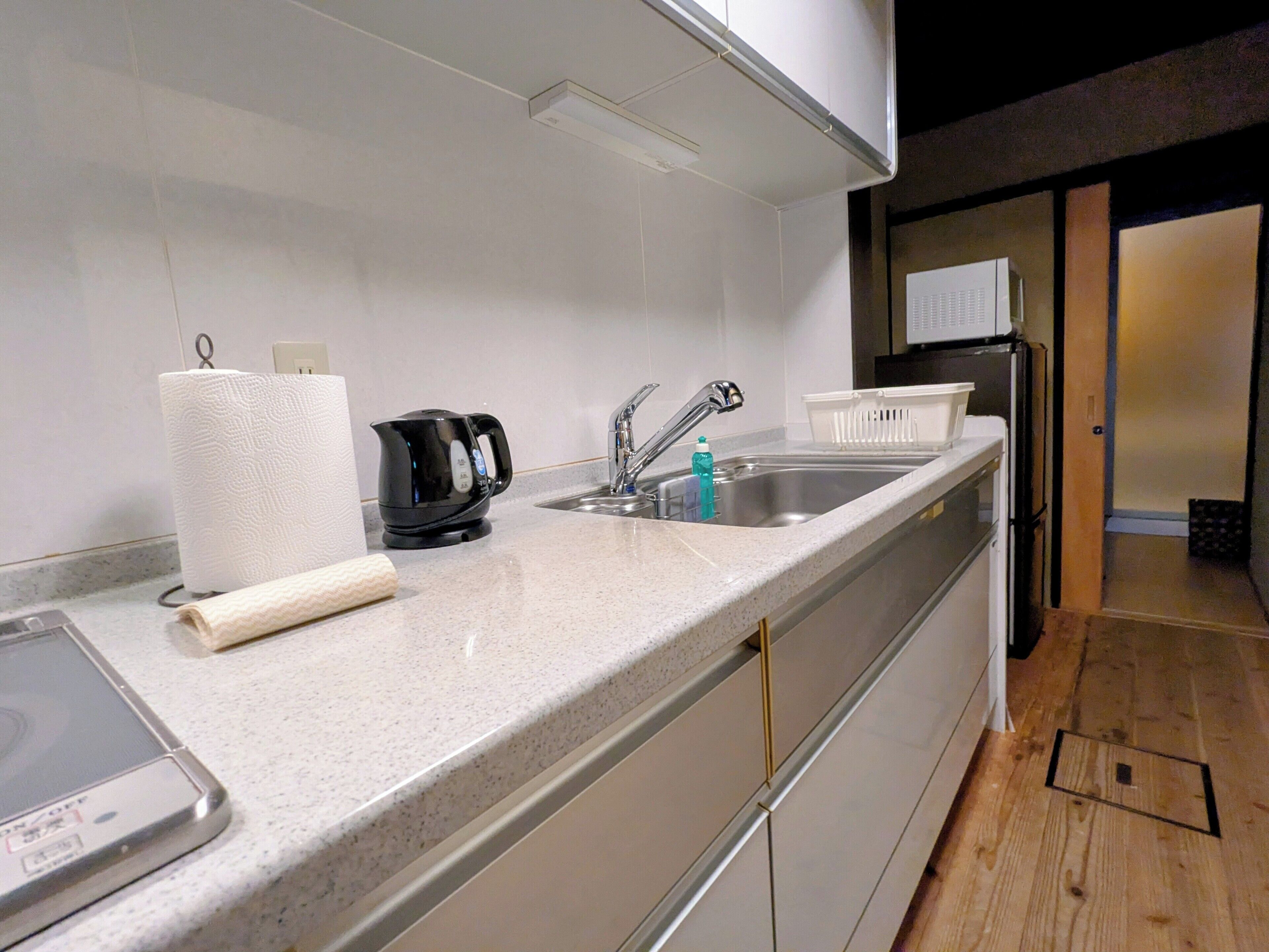 A modern kitchen with a stainless steel sink, a kettle, and a toaster.