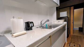 A modern kitchen with a stainless steel sink, a kettle, and a toaster.