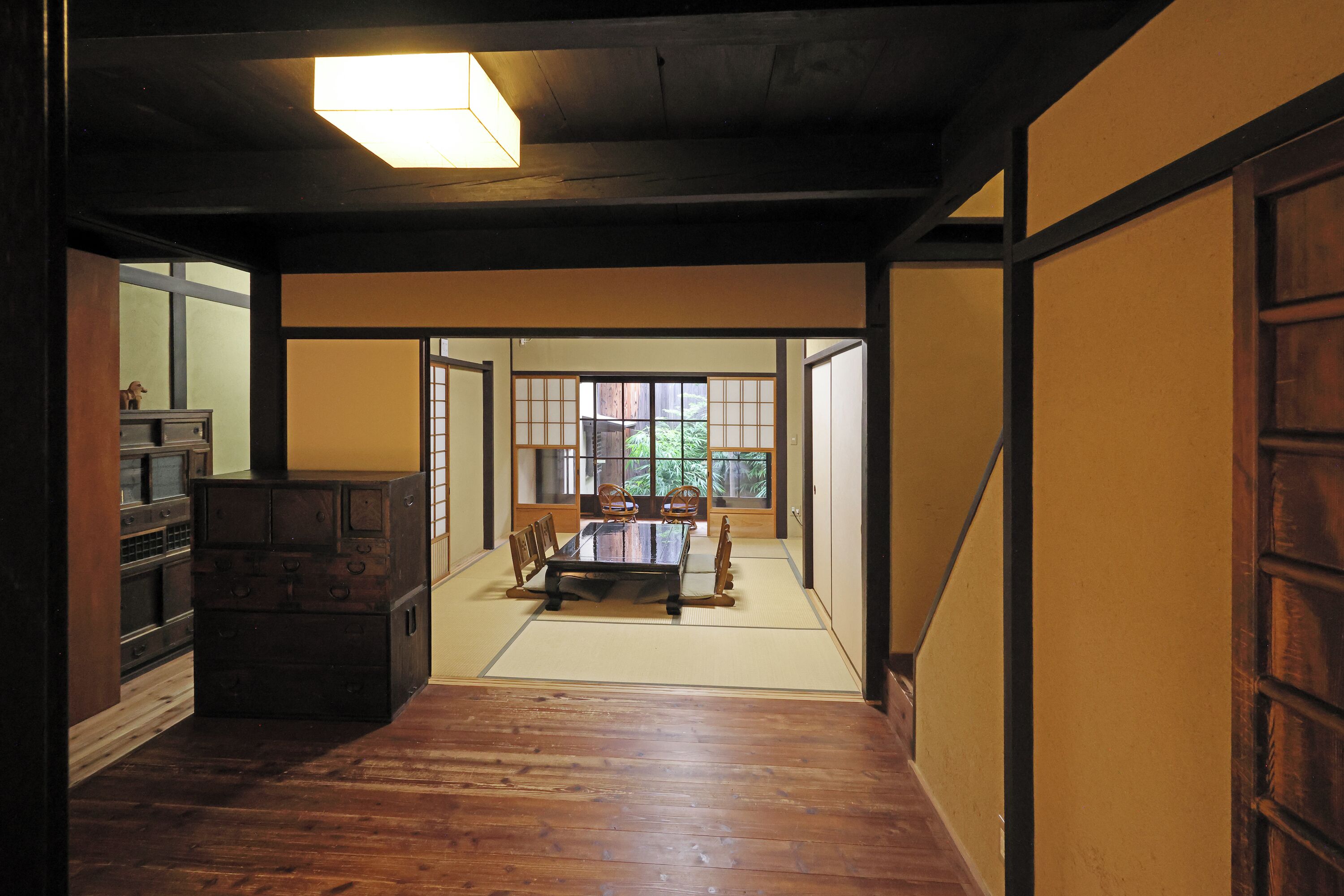 A traditional Japanese room with tatami flooring, a low wooden table, and sliding doors.