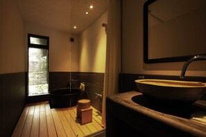 A modern bathroom with a wooden floor, a large vessel sink, and a window with blinds. - Shirafuji-an (Kyoto)