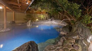 A hot spring area with a wooden ceiling, rocks, and trees. - Ryokan Tokiichiyu (Minamiizu)
