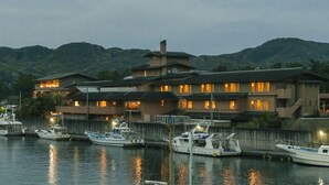 A waterfront hotel with multiple boats docked in front. - Ryokan Tokiichiyu (Minamiizu)
