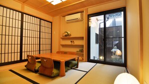 Ein traditioneller japanischer Raum mit Tatami-Bodenbelag, einem niedrigen Holztisch und Shoji-Schirmwänden.