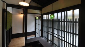 Ein traditioneller japanischer Raum mit Tatami-Böden, Schiebetüren und einem niedrigen Tisch.