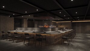 A modern bar area with a long counter, multiple bar stools, and a central fire feature. - Gensen Itto Minamiizu (Minamiizu)
