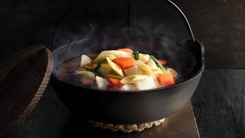 A black pot with a woven base on a dark surface.