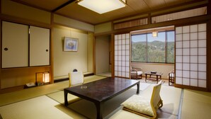 Une pièce de style japonais traditionnel, avec un sol recouvert de tatamis, une table basse et des portes coulissantes.