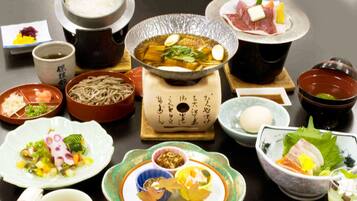 A variety of Japanese dishes including a hot pot, sashimi, and noodles.