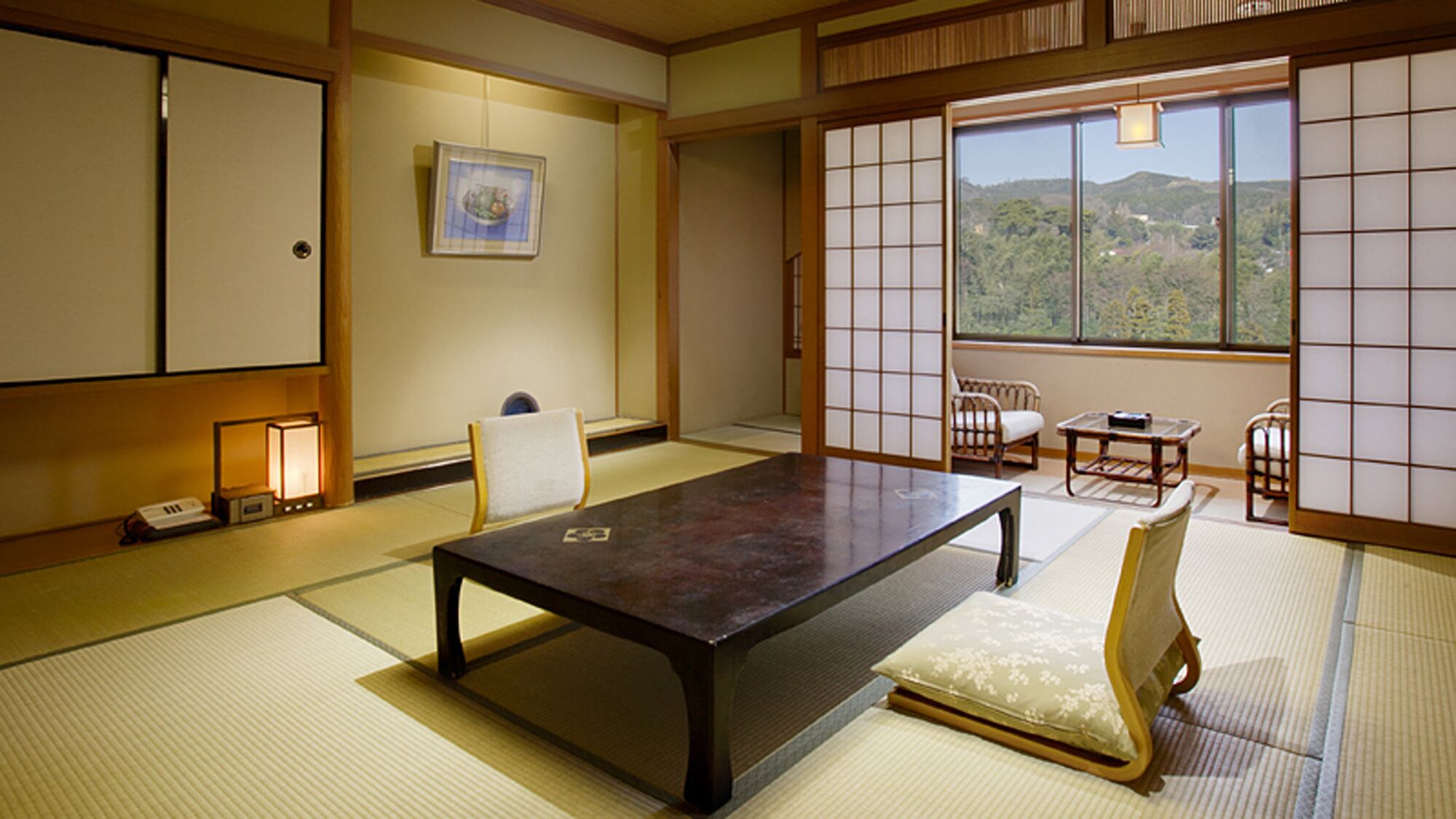 A traditional Japanese room with tatami flooring, a low table, and sliding doors.