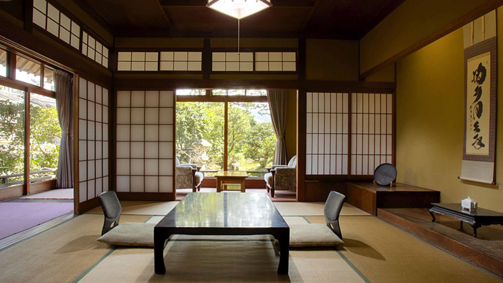 A traditional Japanese room with tatami flooring, a low table, and sliding doors.