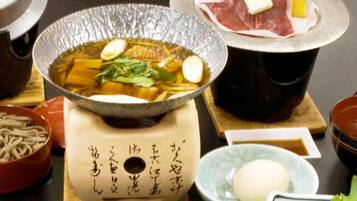 Een hete pot opstelling met diverse ingrediënten en een houten standaard met Japanse tekst.