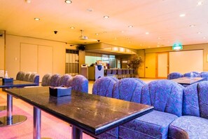 A conference room with a long table and multiple rows of chairs. - Hotel Kawachiya (Minamiizu)