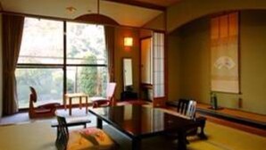 Una habitación tradicional japonesa con suelo de tatami, una mesa baja y una puerta corrediza.
