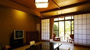 Una habitación japonesa tradicional con suelo de tatami, una mesa baja y puertas correderas shoji.