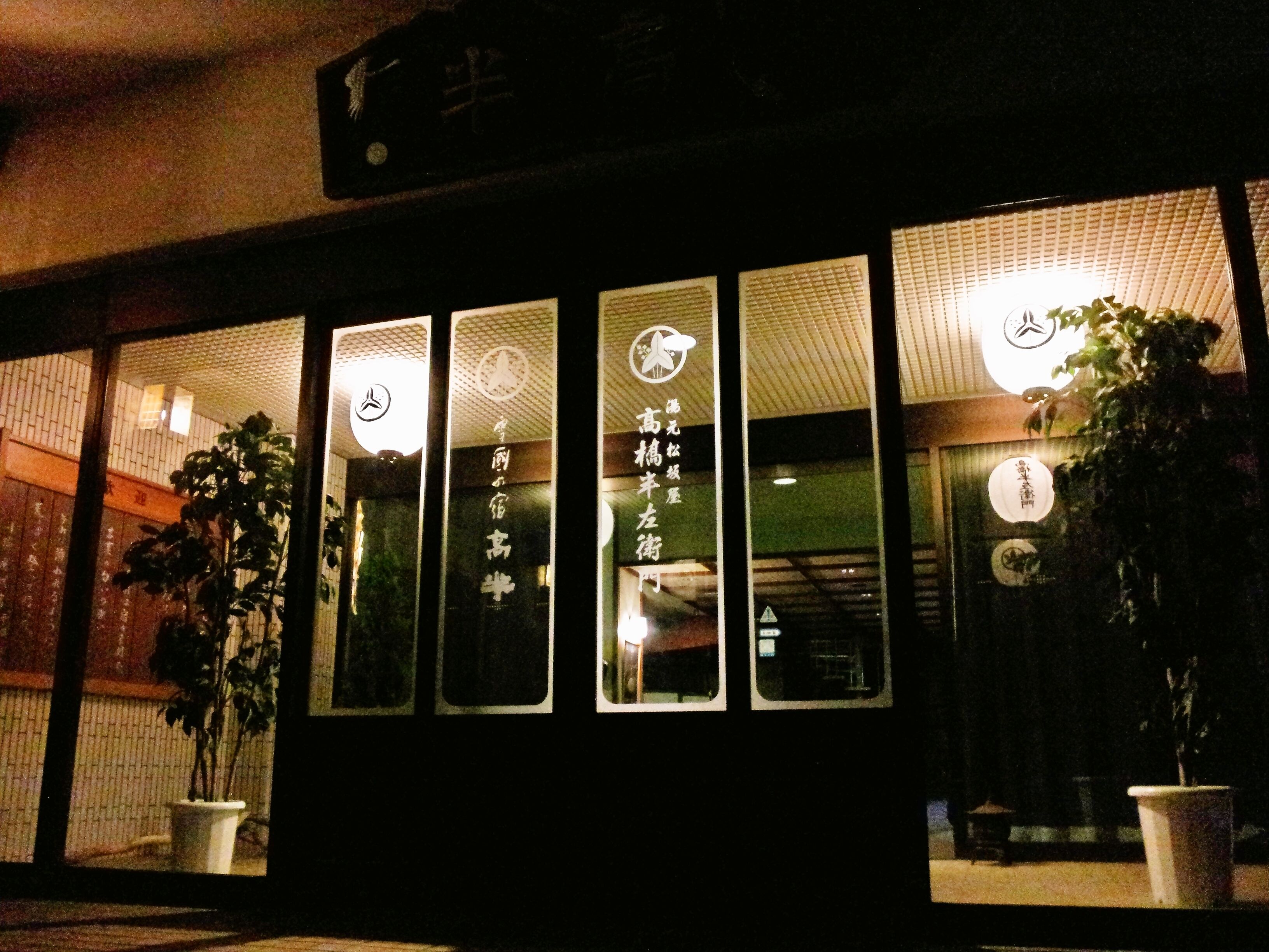 Fachada de edificio con varias ventanas, algunas con letreros iluminados.