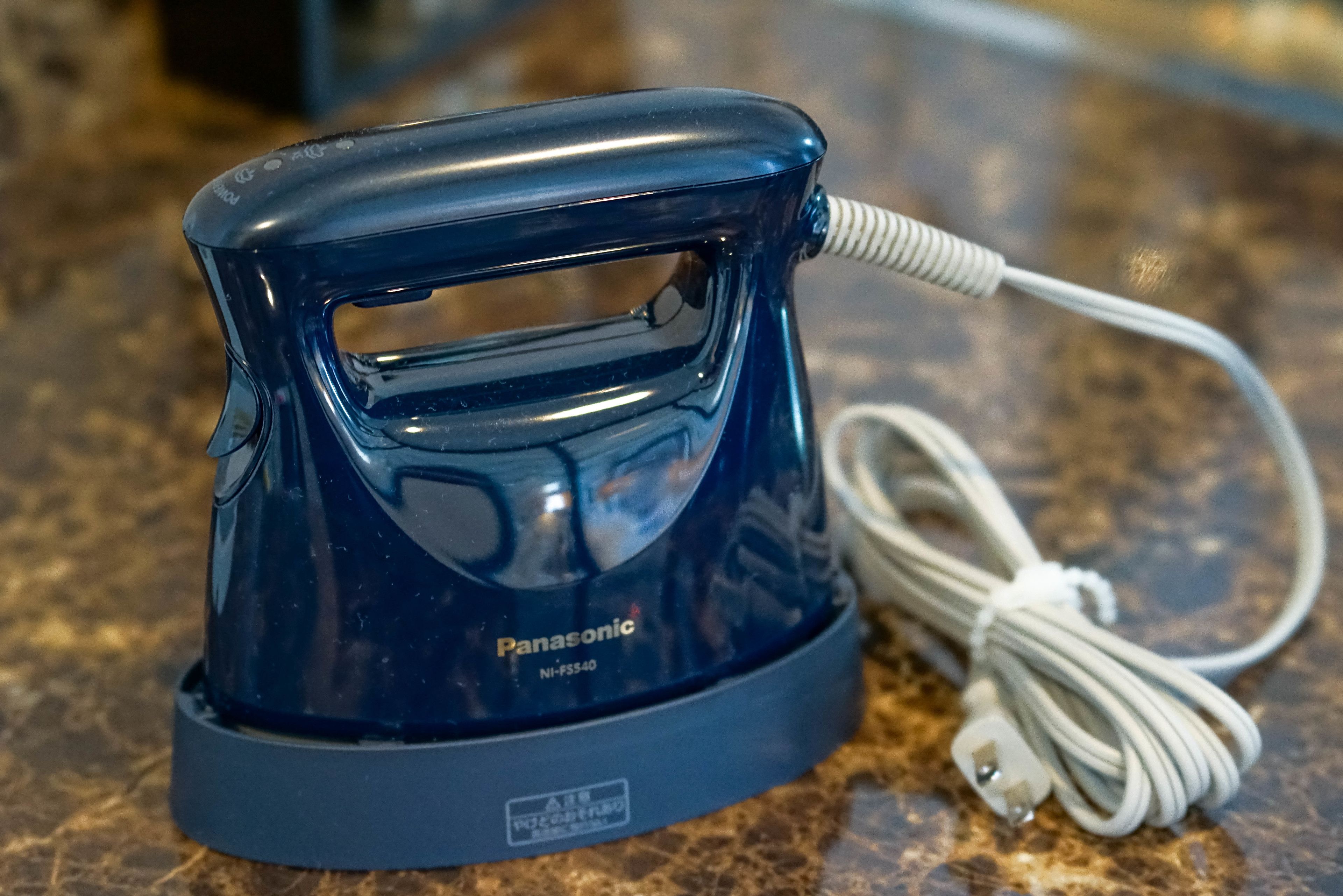 A Panasonic electric kettle with a cord on a granite countertop.