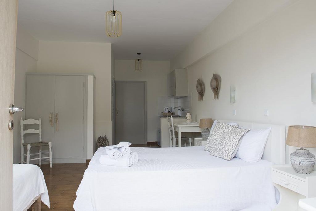 A bedroom with a bed, bedside tables, a desk, and a chair.