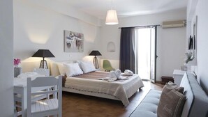 Una camera da letto con un letto, lampade da comodino, una scrivania, una sedia, un divano e una finestra con tende.