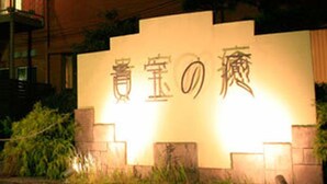 Een bord met Japanse karakters, waarschijnlijk de naam van een hotel of gebouw.