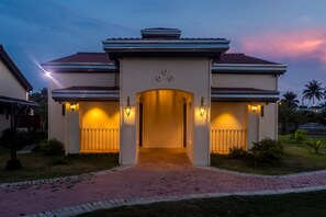 A modern house with a central entrance, two side entrances, and a brick pathway leading to the front. - Espacio Verde Resort (Roxas City)