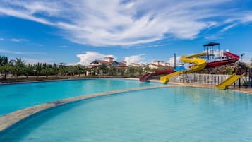 Een buitenzwembad, ligstoelen bij het zwembad