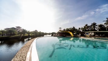 Una piscina al aire libre, sillones reclinables de piscina