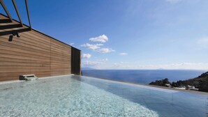 An infinity pool with clear water, wooden walls, and a view of the sea. - Atagawa Prince Hotel (Higashiizu)