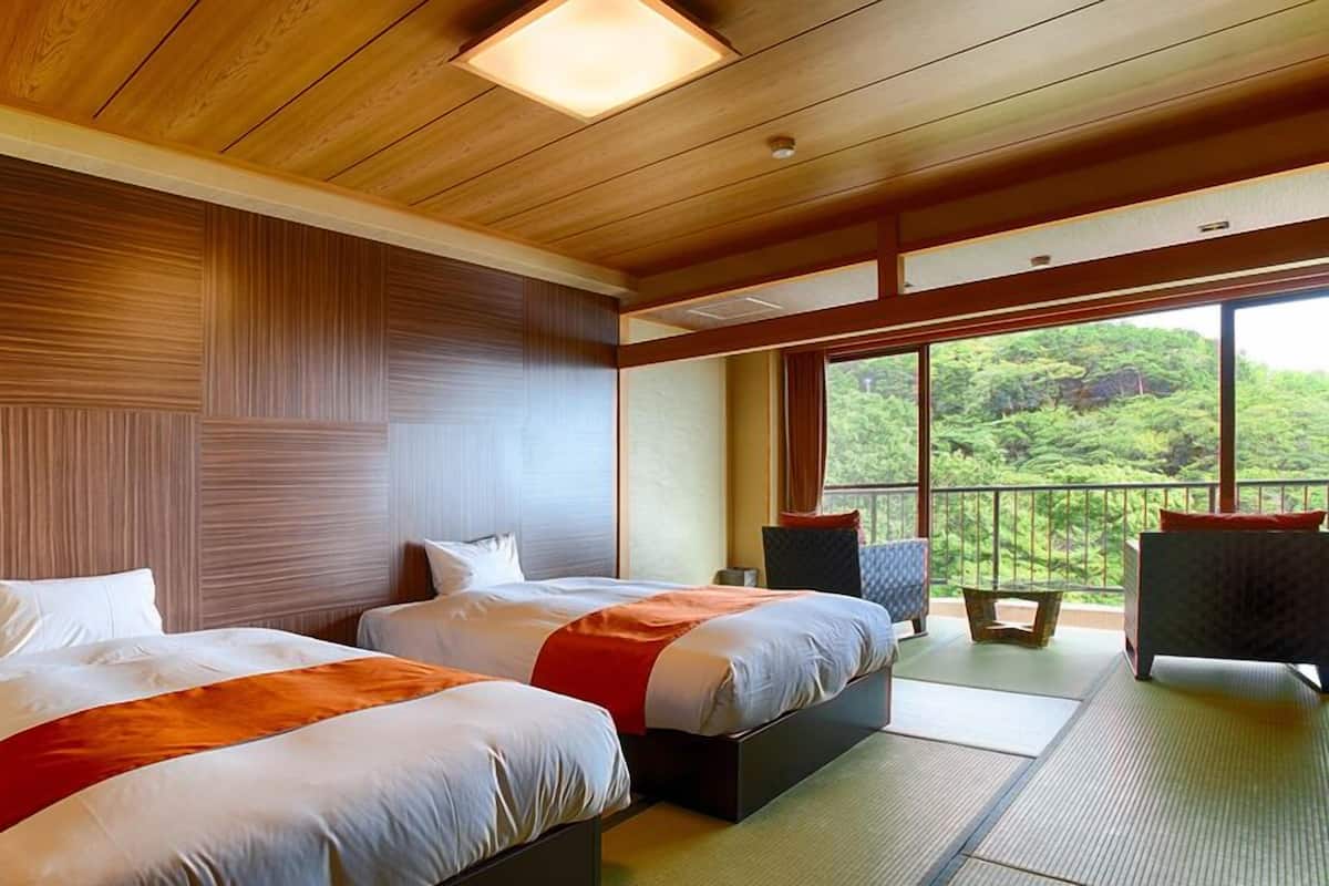 A hotel room with two beds, a balcony with a view of greenery, and a wooden ceiling.