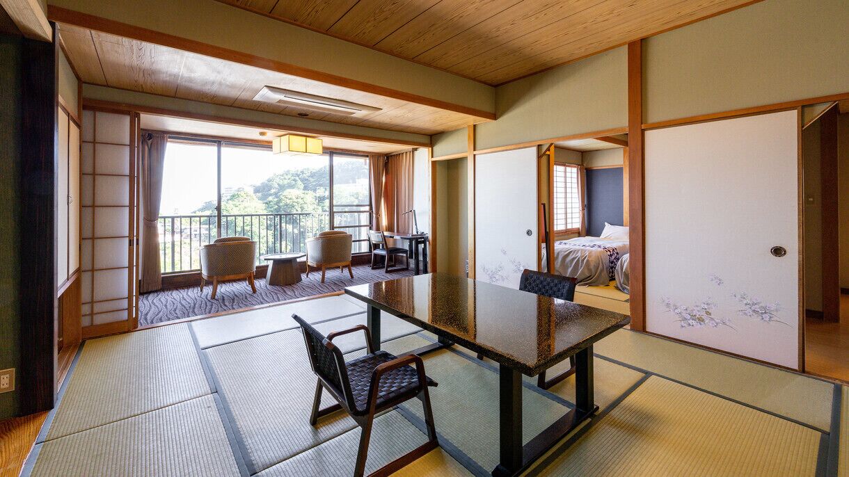 Una habitación japonesa tradicional con suelo de tatami, una mesa baja y una cama con un shoji.