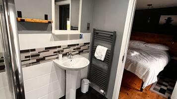 A compact bathroom with a white sink, mirror, and towel rack.