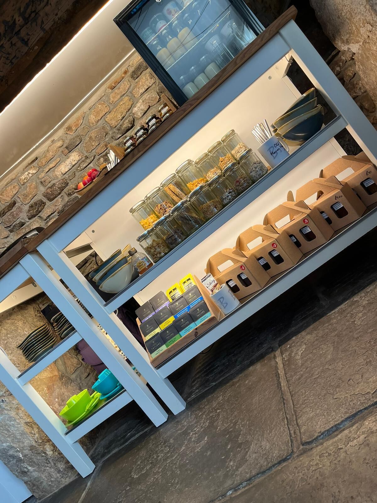 Una encimera de cocina con frascos de especias, una máquina de café y una exhibición de productos envasados.